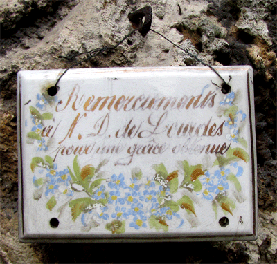 Inscription fleurie : Remerciements à N-D de Lourdes pour une grâce obtenue.